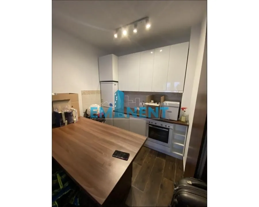 Small kitchen with white cabinets and a dining table.