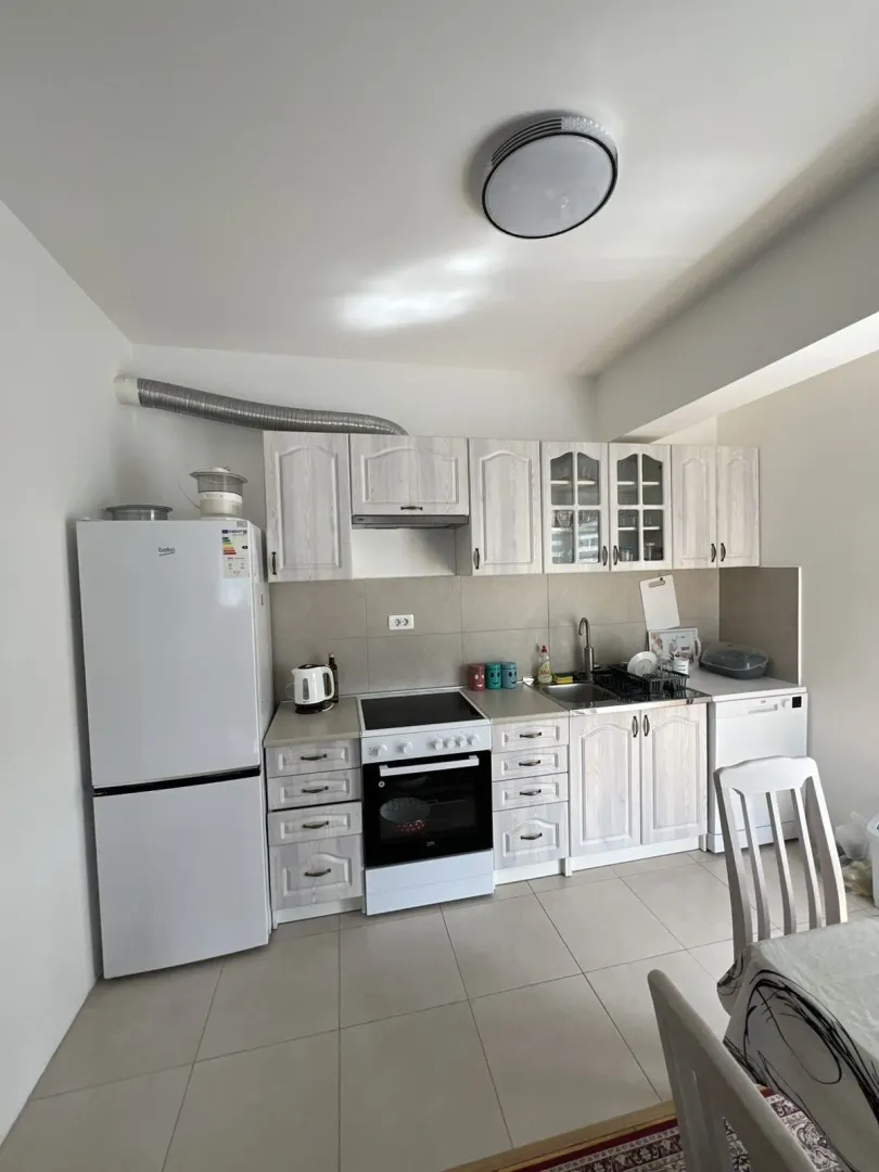 Bright kitchen with white cabinets and appliances.