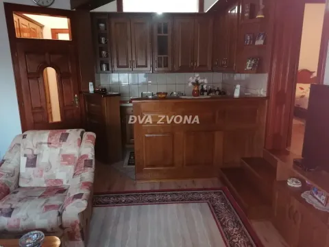 Living room with wooden kitchen elements and an armchair. - image 23