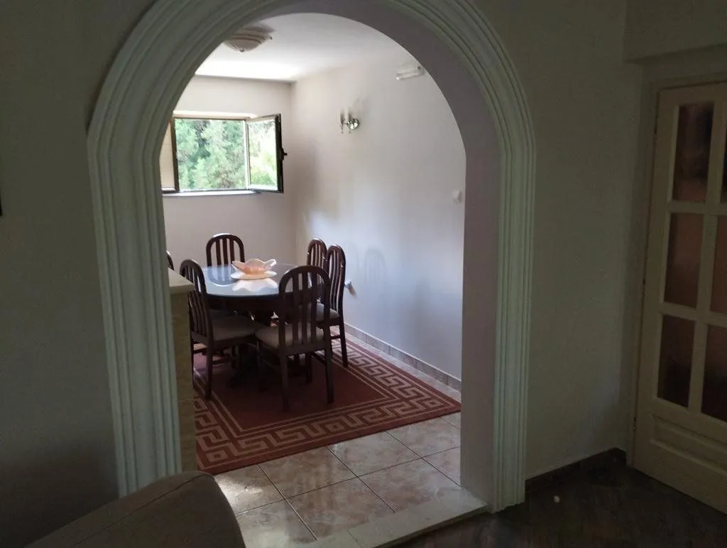 View through a decorative archway into the dining room with a table and chairs.