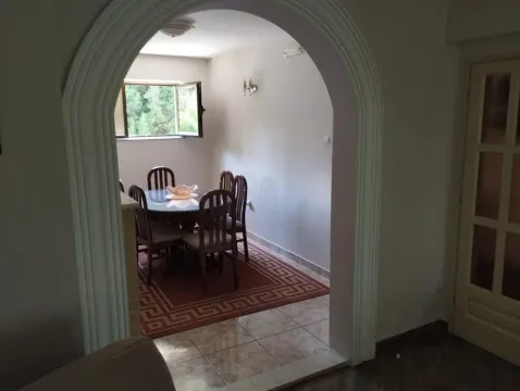 View through a decorative archway into the dining room with a table and chairs. - image 12