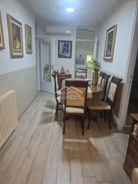 Dining area with a table, chairs, and paintings on the wall. - image 6