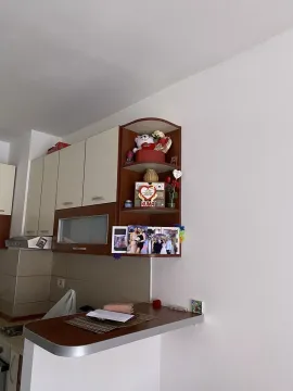 Kitchen cabinets with a small bar counter and decorative shelves. - image 6