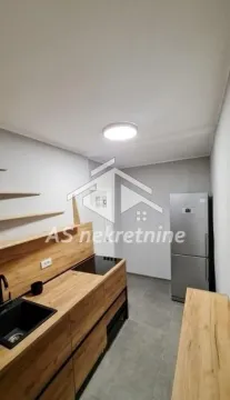 Manja kuhinja sa drvenim elementima i frižiderom. - image 3