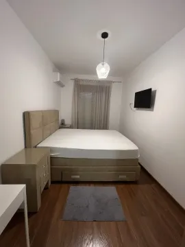 Svijetla spavaća soba sa bračnim krevetom i televizorom na zidu. - image 16