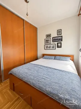 Namještena spavaća soba sa velikim bračnim krevetom i drvenim ormarom. - image 6