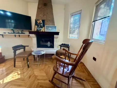 Living room with a fireplace, wooden floor, and armchairs. - image 9
