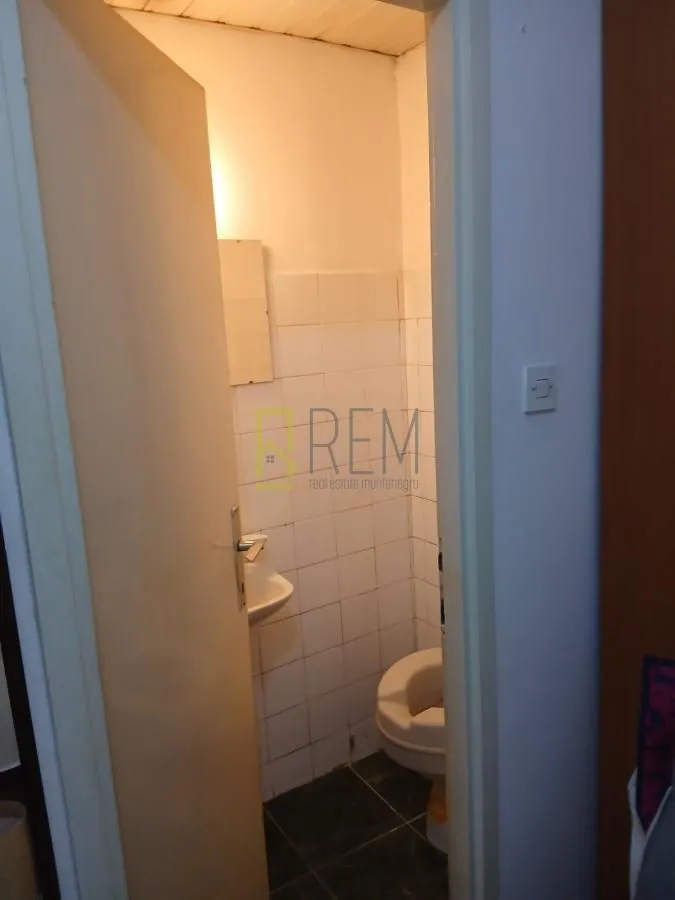 Smaller bathroom with sanitary facilities and white tiles.