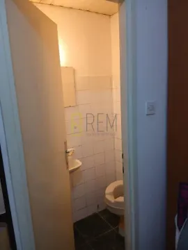 Smaller bathroom with sanitary facilities and white tiles. - image 13