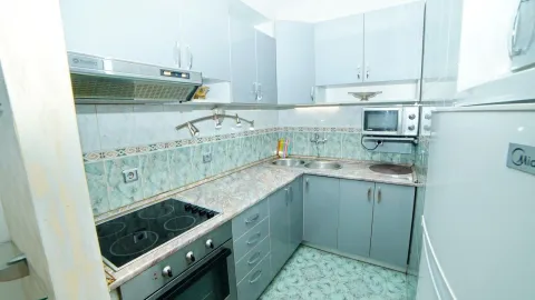 A functional kitchen with light cabinets and built-in appliances. - image 11