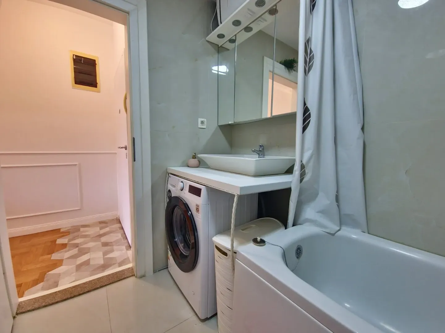 Bathroom with a sink, bathtub, and washing machine.