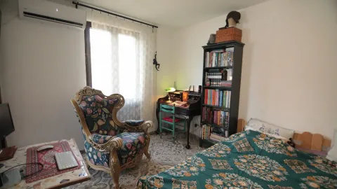 Namještena spavaća soba sa krevetom, foteljom, radnim stolom i police sa knjigama. - image 6