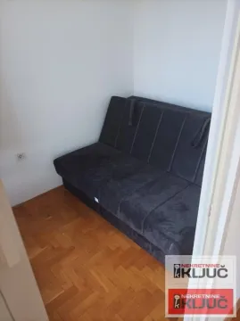 Manja soba sa tamnim dvosedom i parketom na podu. - image 13