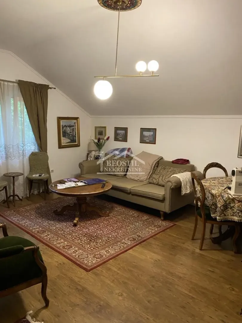 Dnevna soba sa garniturom, stočićem i trpezarijskim stolom.