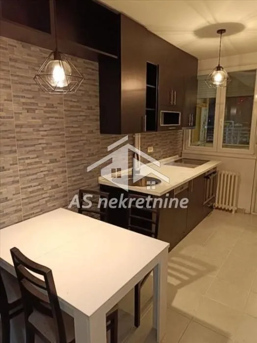 Kitchen with dining table and dark cabinetry.