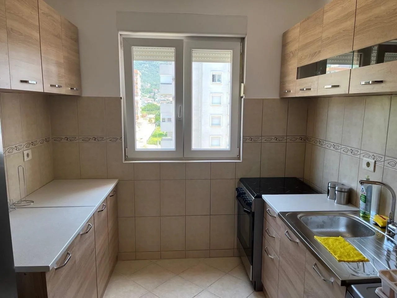 Small kitchen with wooden cabinetry and a window.