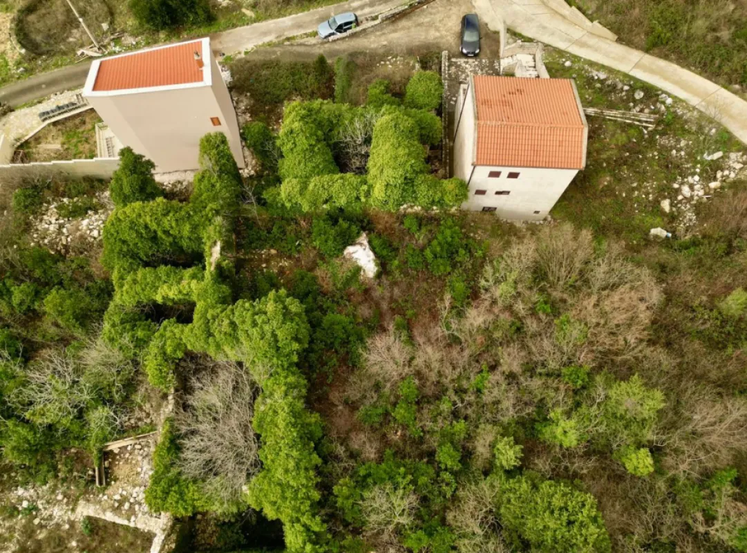 Pogled iz vazduha na imanje i kuće okružene zelenilom.