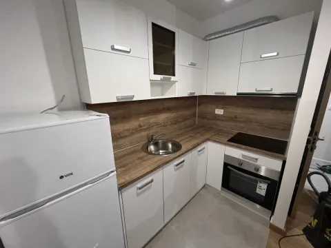 Modern kitchen with white cabinets, wooden countertop, and built-in appliances. - image 10