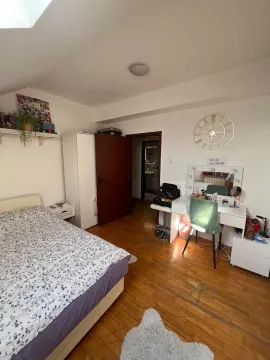 Nameštena spavaća soba sa krevetom, radnim stolom i drvenim podom. - image 12