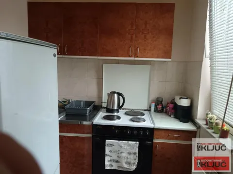 Manja kuhinja sa drvenim elementima, šporetom i frižiderom. - image 8