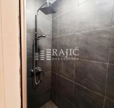 Modern shower enclosure tiled with dark tiles. - image 8