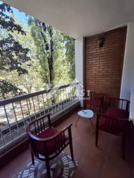 Natkriveni balkon sa garniturom za sedenje i pogledom na zelenilo. - image 10