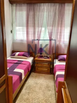 Bedroom with two single beds and a window with curtains. - image 9