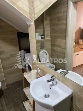 Small bathroom clad in wood-effect ceramic tiles with a washbasin and toilet. - image 10