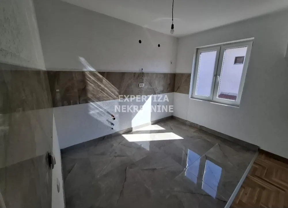 Empty kitchen with ceramic tiles and a window.