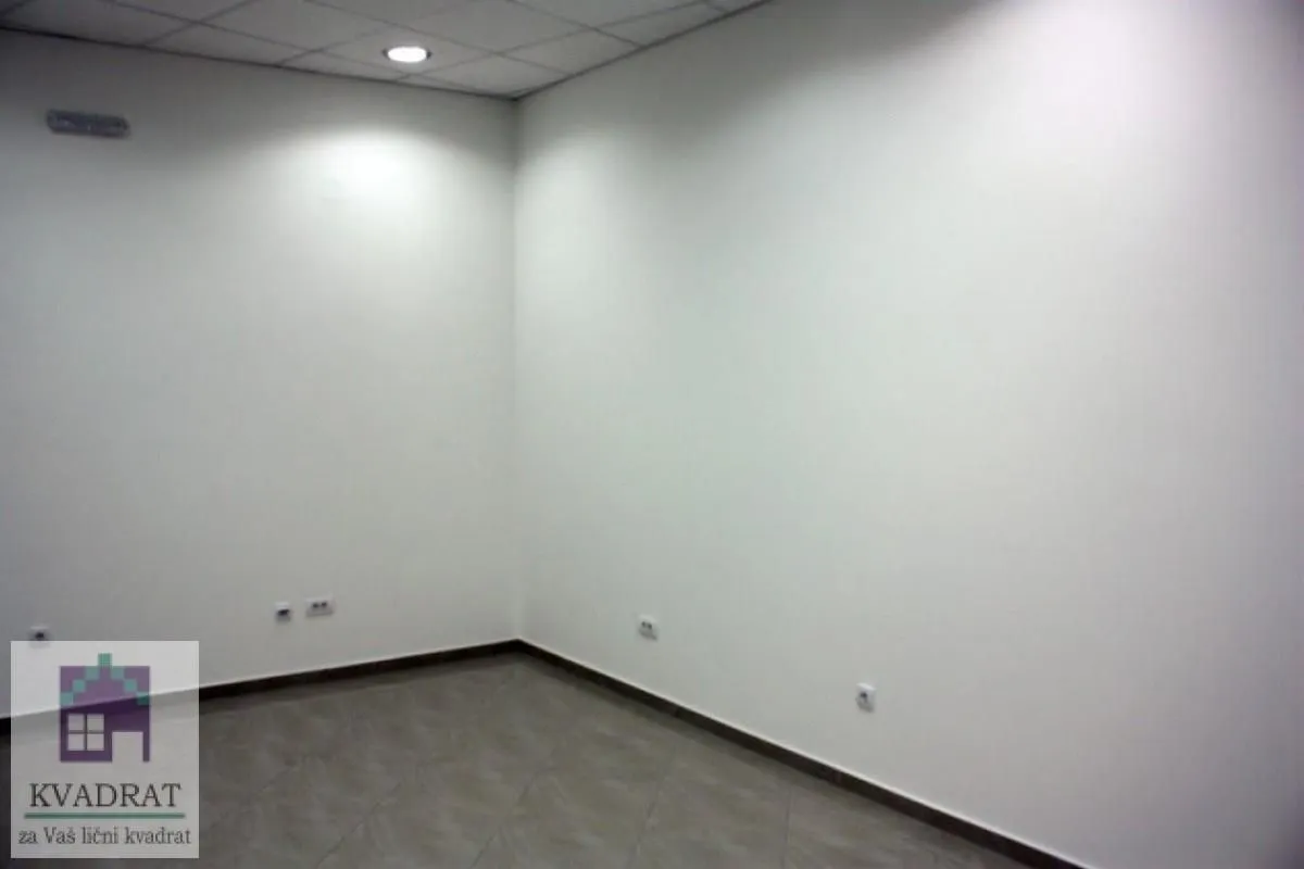 An empty room with white walls and tiled flooring.