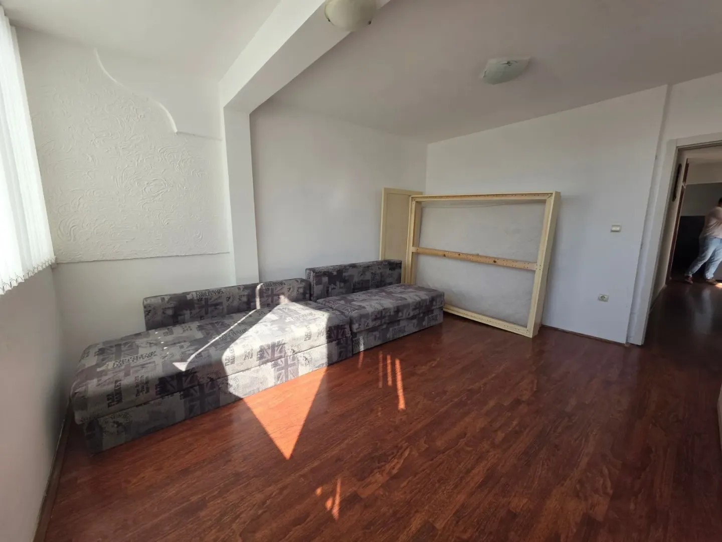 Living room with dark wooden flooring and a sofa.
