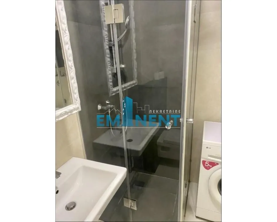 Small bathroom with a shower cabin and a sink.
