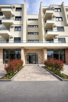 Main entrance and facade of a modern residential building with a landscaped yard. - image 5