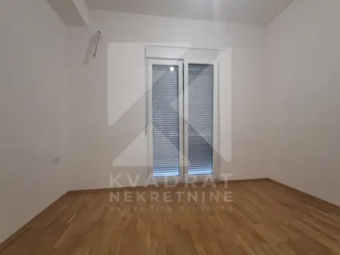 Empty unfurnished room with parquet flooring and balcony doors with roller shutters. - image 10