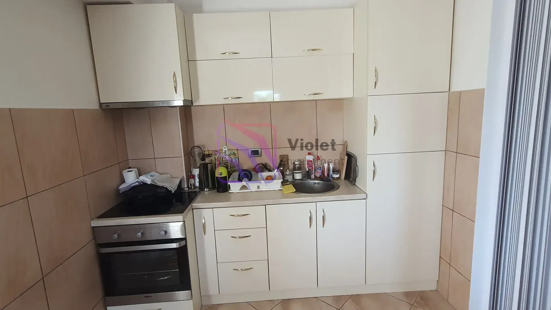 Small kitchen with white cabinets and built-in appliances.