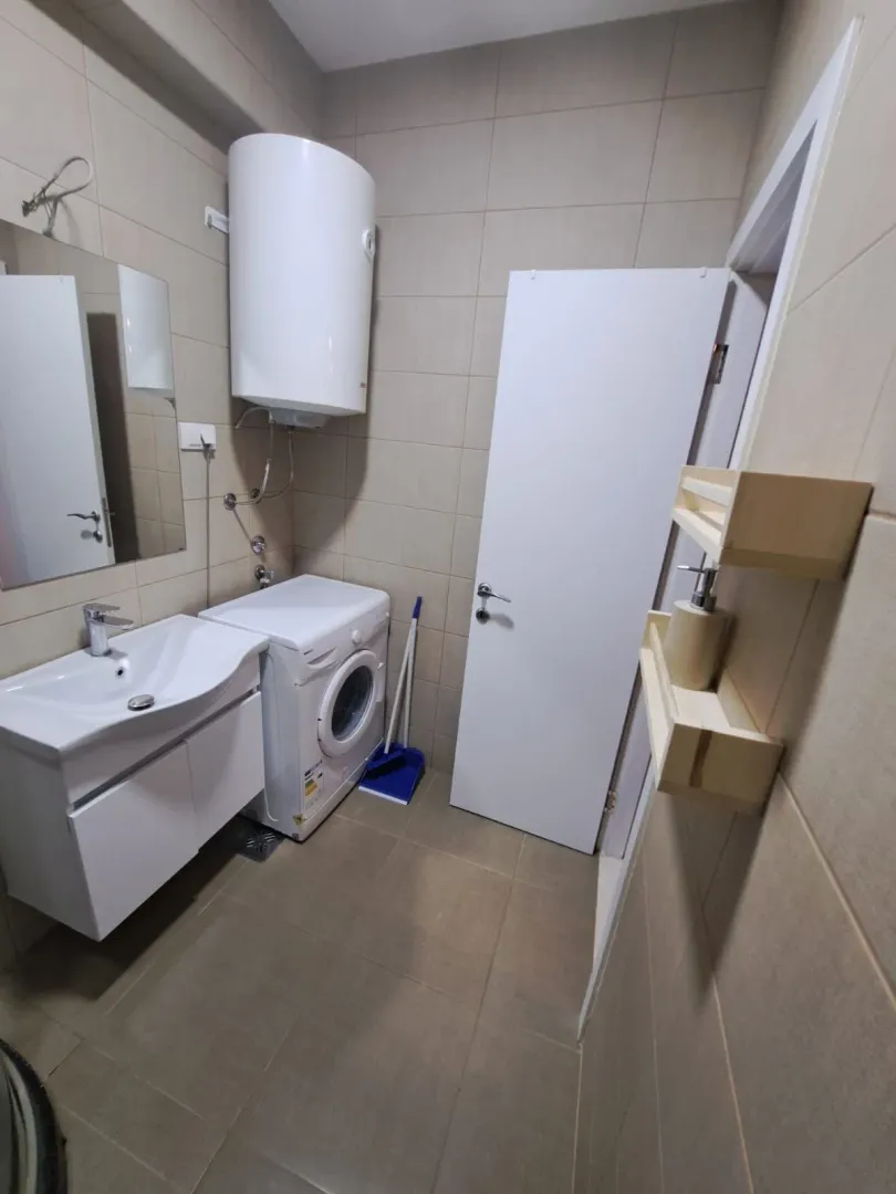 Kupatilo opremljeno umivaonikom, veš mašinom i bojlerom.