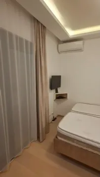 A bedroom with beds, air conditioning, and a wall-mounted TV. - image 7
