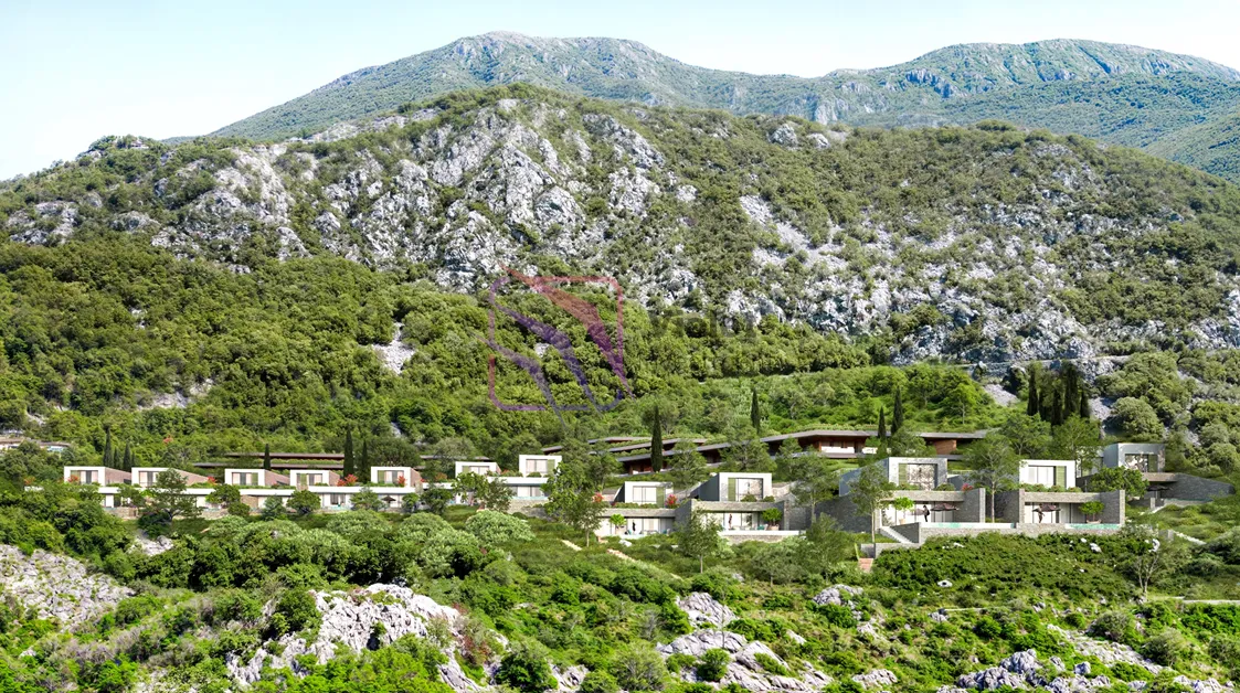 Pogled na kompleks vila u izgradnji okružen planinskim pejzažom.