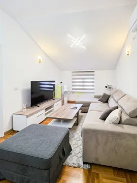 Living room with a sectional sofa, TV, and coffee table. - image 8