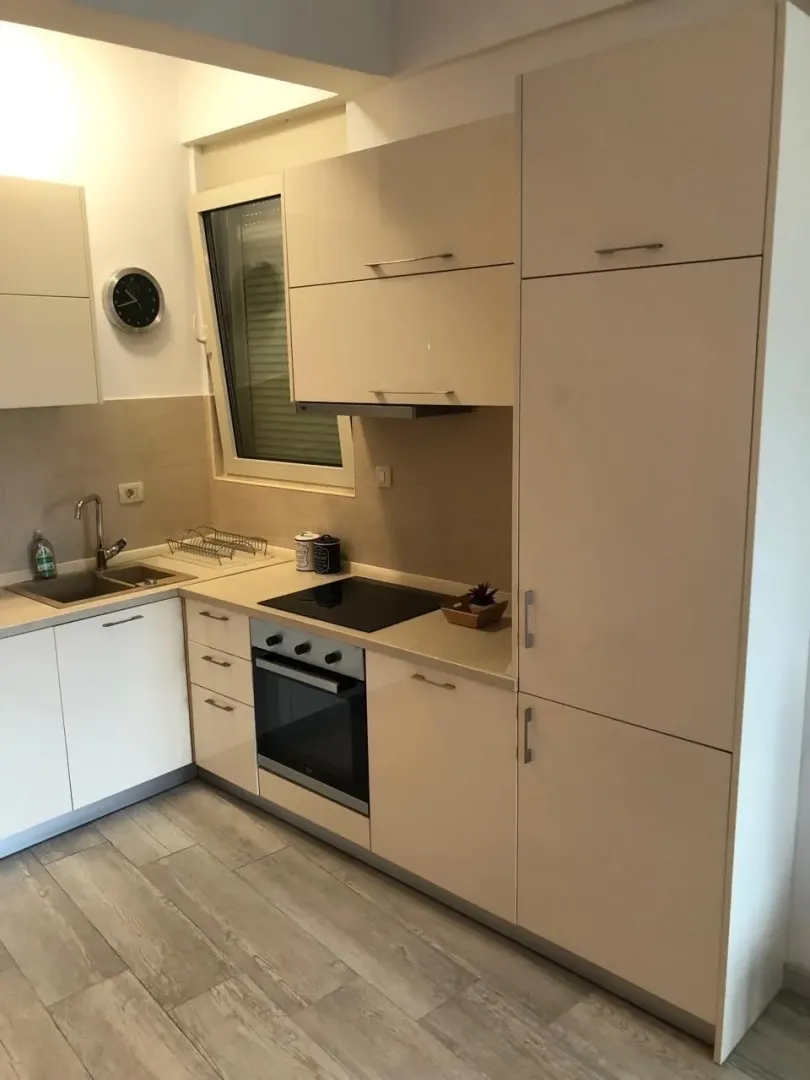 Modern kitchen with light cabinets and built-in oven.