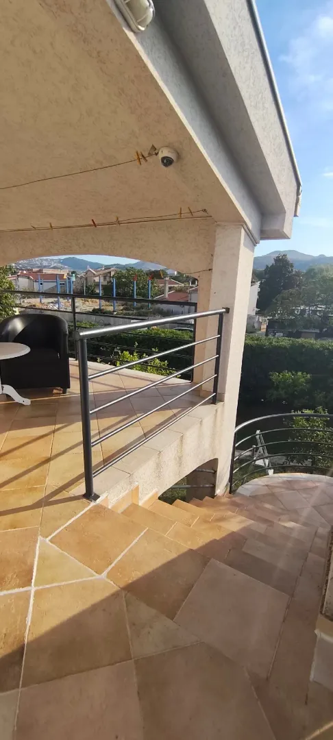 Covered terrace with a view of the surroundings and stairs leading down.
