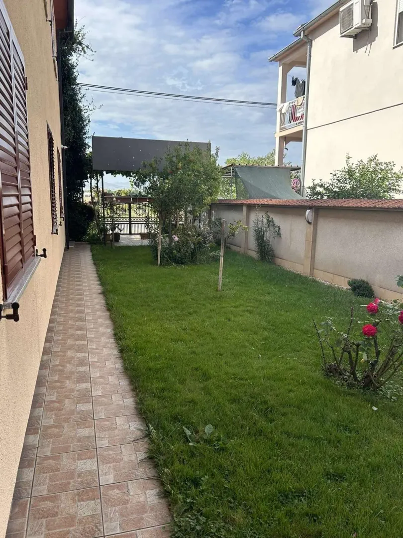 A landscaped yard with a green lawn next to the house.