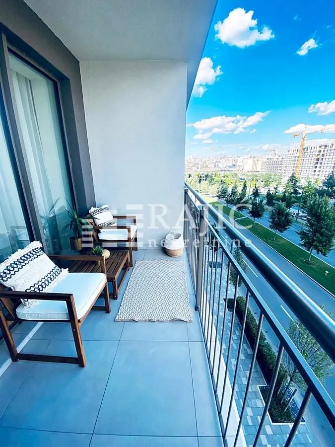 Furnished balcony with seating set and city view.