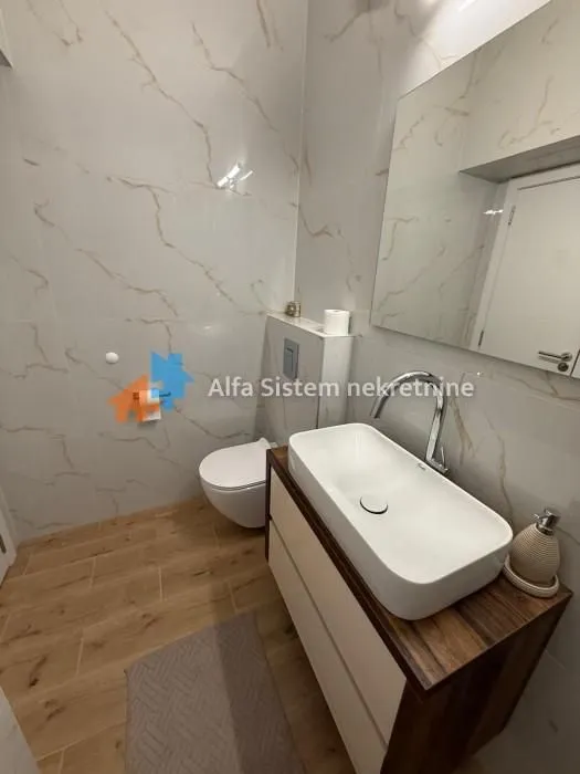 Savremeno opremljeno kupatilo sa umivaonikom i wc šoljom.