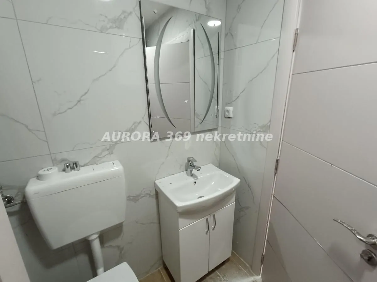 Manje kupatilo sa umivaonikom, ormarićem i wc šoljom.