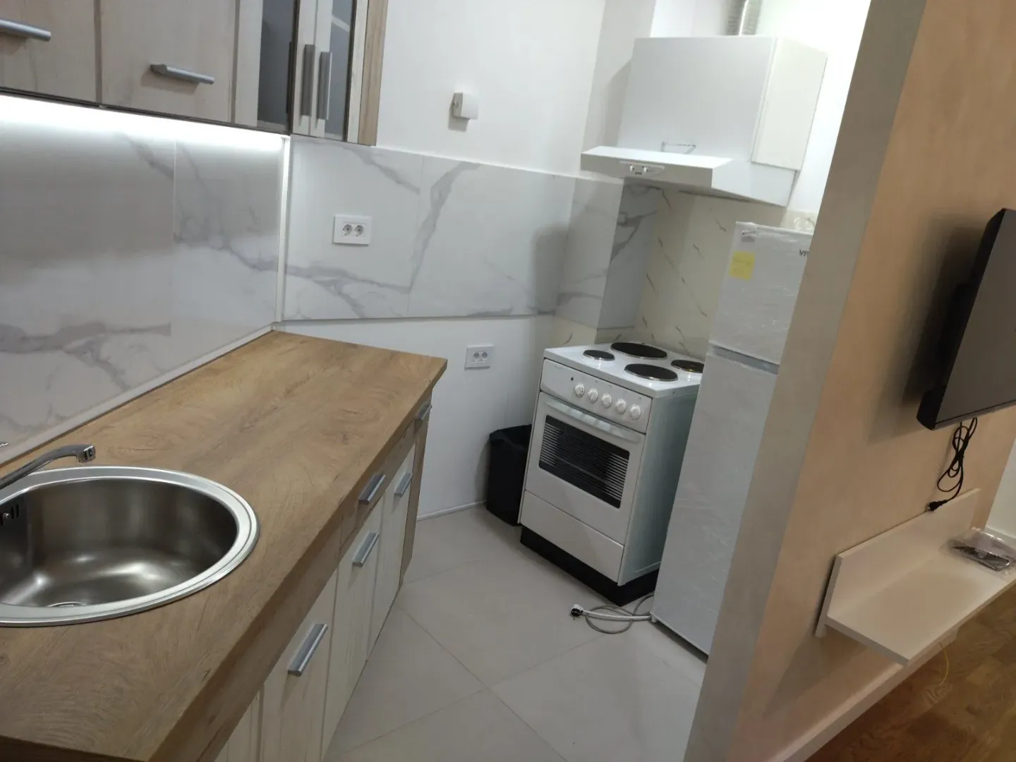Small kitchen with a wooden countertop and built-in appliances.