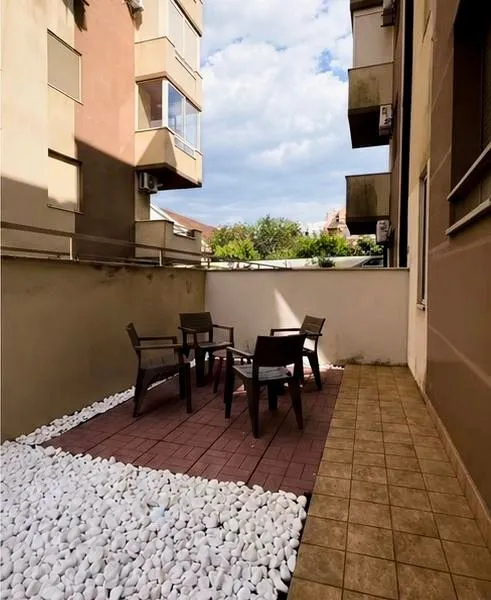 Manja terasa sa garniturom za sjedenje i popločanim podom.