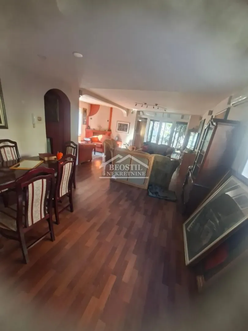 Spacious living room with a dining area and wooden flooring.