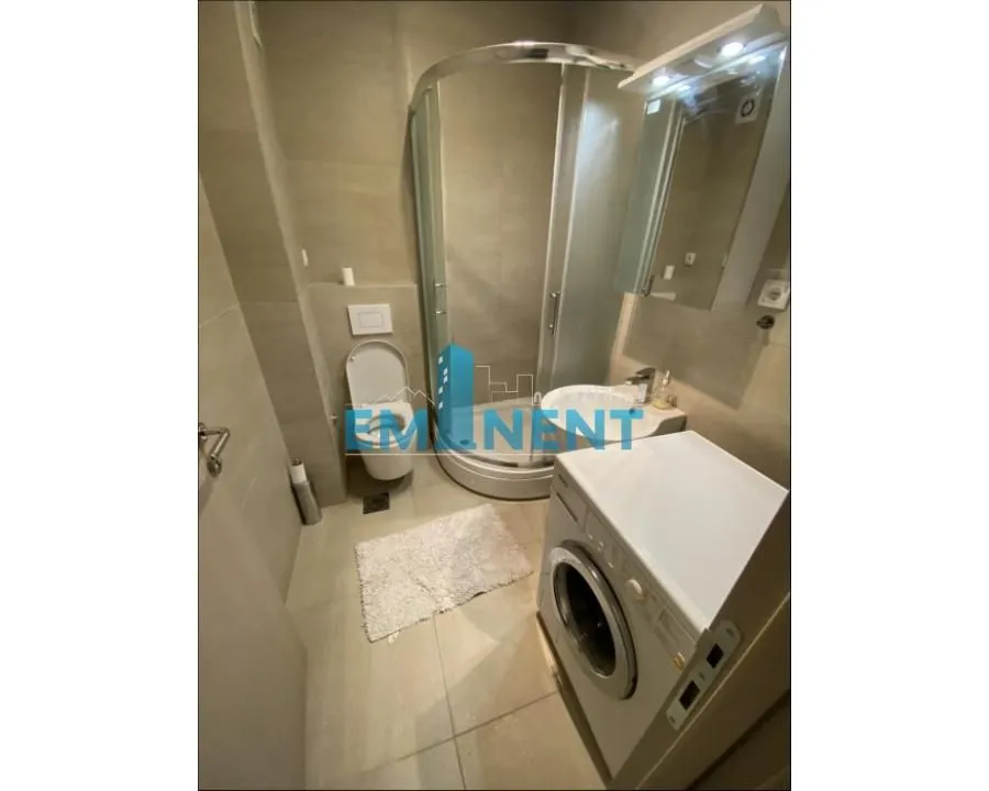 Bathroom equipped with a shower cabin, washbasin, toilet, and washing machine.
