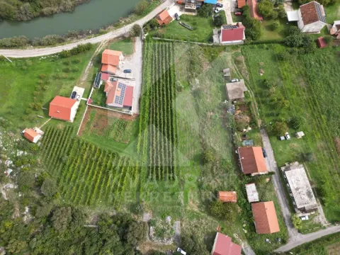 Pogled iz vazduha na imanje sa kućama, voćnjacima i rijekom u blizini. - image 2